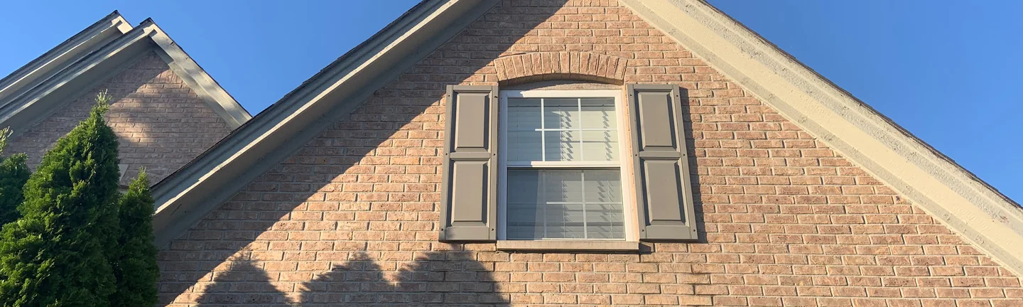 The gable end of the house at Shadow Lake in 2019, its brick reading as one tan and brown range