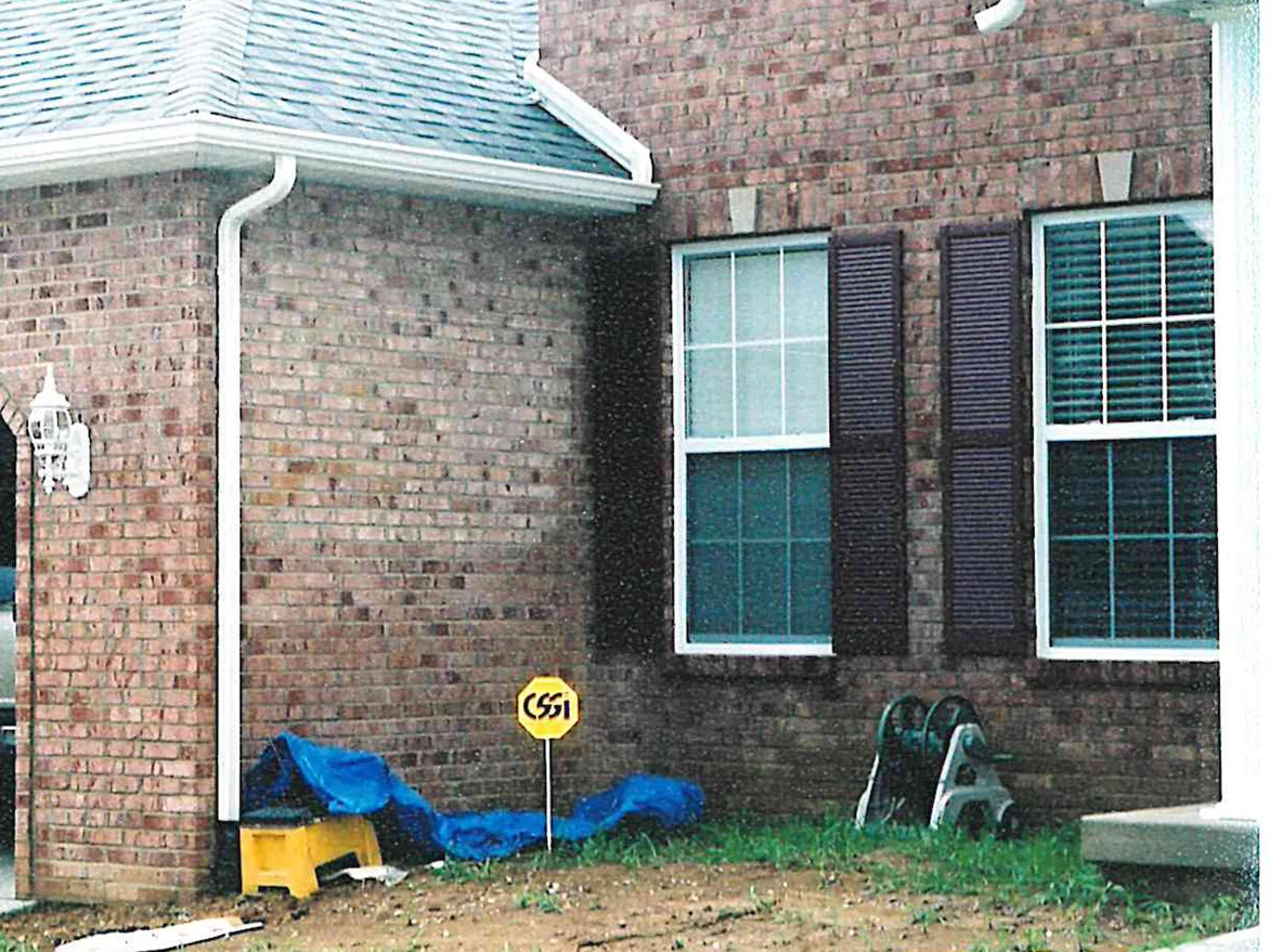 The front of the house in 2003, the garage wing at the left in a pale pink and tan brick and the two-story section beyond it in a darker red brown