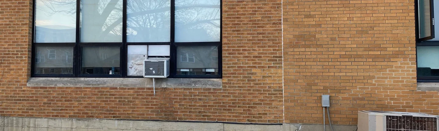 The window bay of the Skokie building in 2021, tan brick running unbroken from the new section into the existing wall beyond the vertical joint