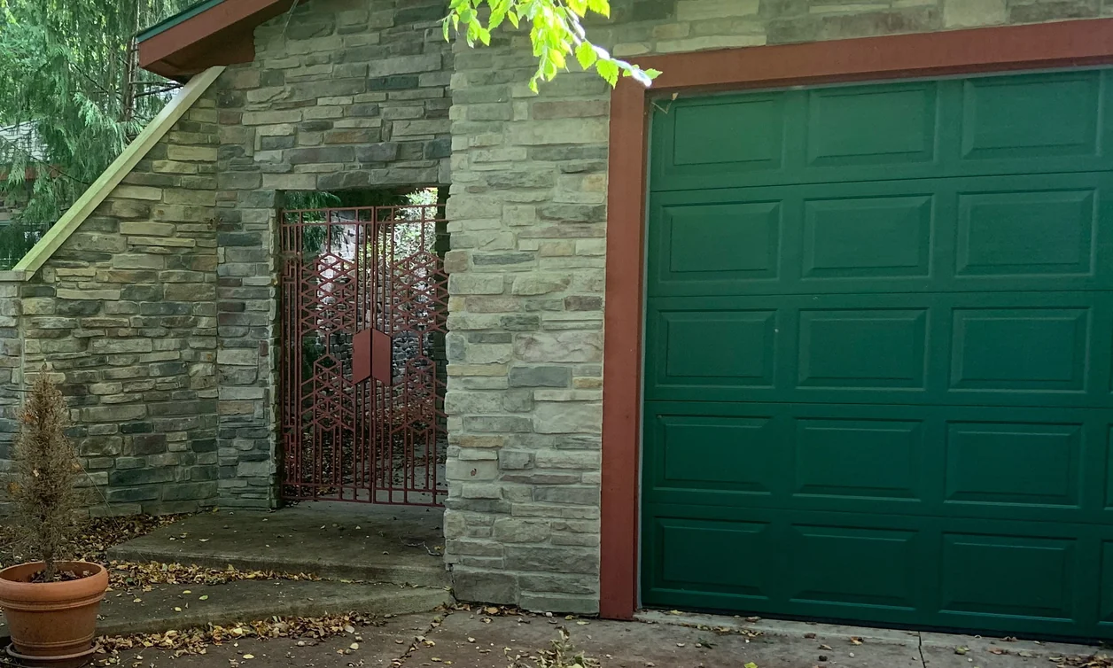 A stone garage entrance on an Ohio home in 2019, burgundy units blended into the range twenty-one years after staining