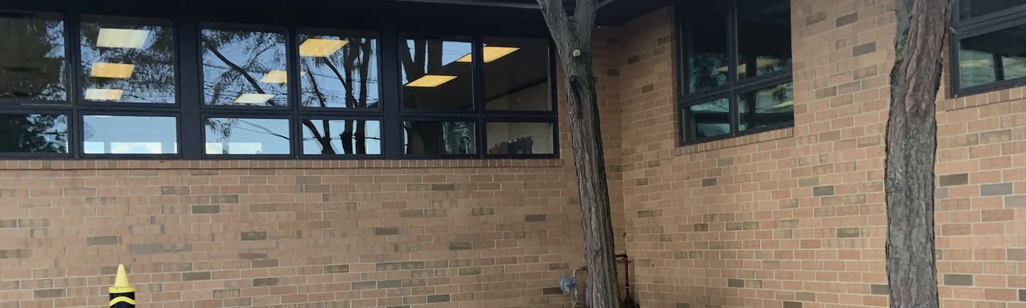 The stained brick of the Solon entry elevation in 2019, running as one buff and tan range under a band of clerestory windows