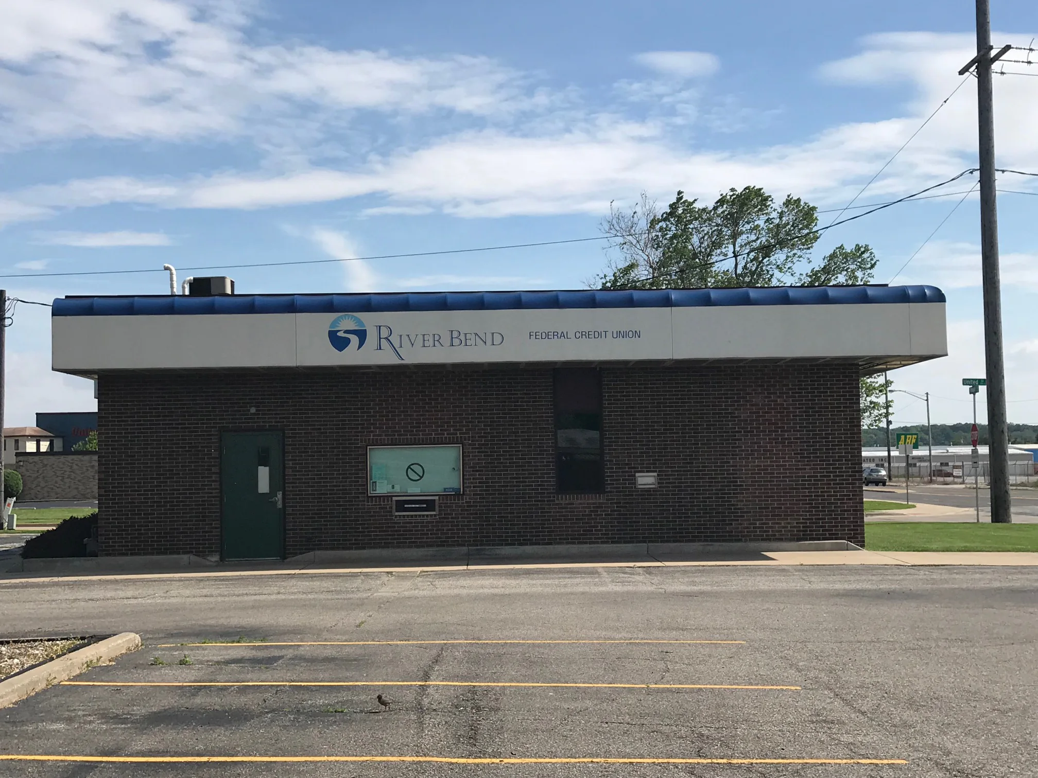 The same front elevation in 2019, the brick still reading as one dark red brown from across the parking lot