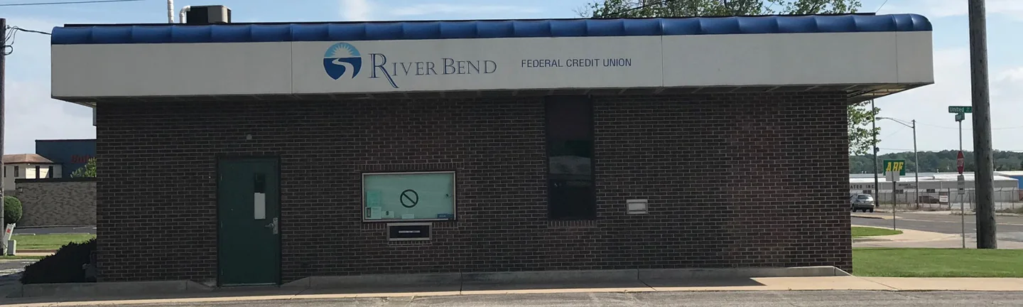 A single-story bank in South Bend in 2019, its brick one dark red brown under a blue barrel canopy