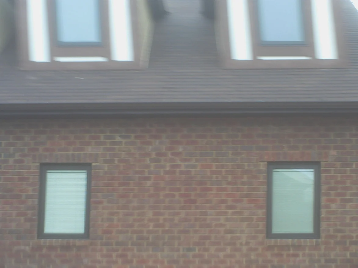 A wall of the addition in 2008, its brick a plain red with cream and near-black units banded under the eaves and stacked at the corners