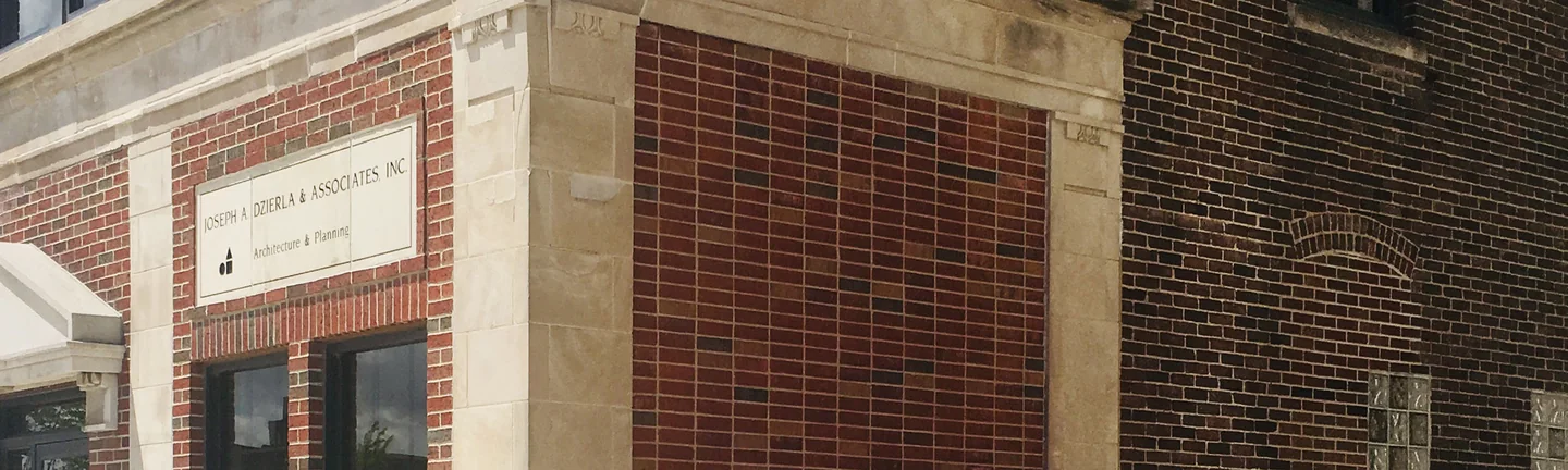 The stained alley wall of a South Bend architect's office in 2019, reading as one even red and brown wall