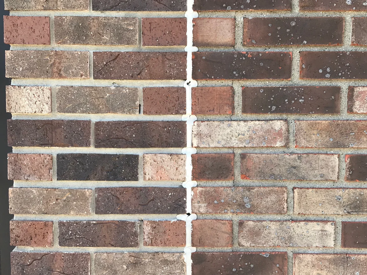 Close view of the brick at an outside corner in 2019, the mortar joints raked deep into shadow and clean of stain on every course