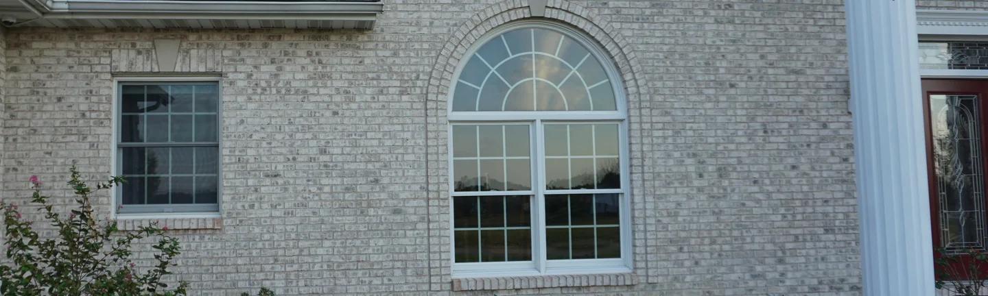 Cream and buff brick across the front of the Sparta house in 2019, reading as one blend around an arched window