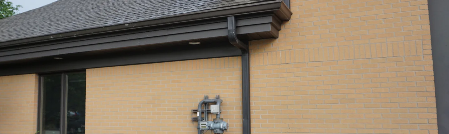 A fire station in St Clair, Michigan in 2019, its buff brick running one even color under a dark soffit