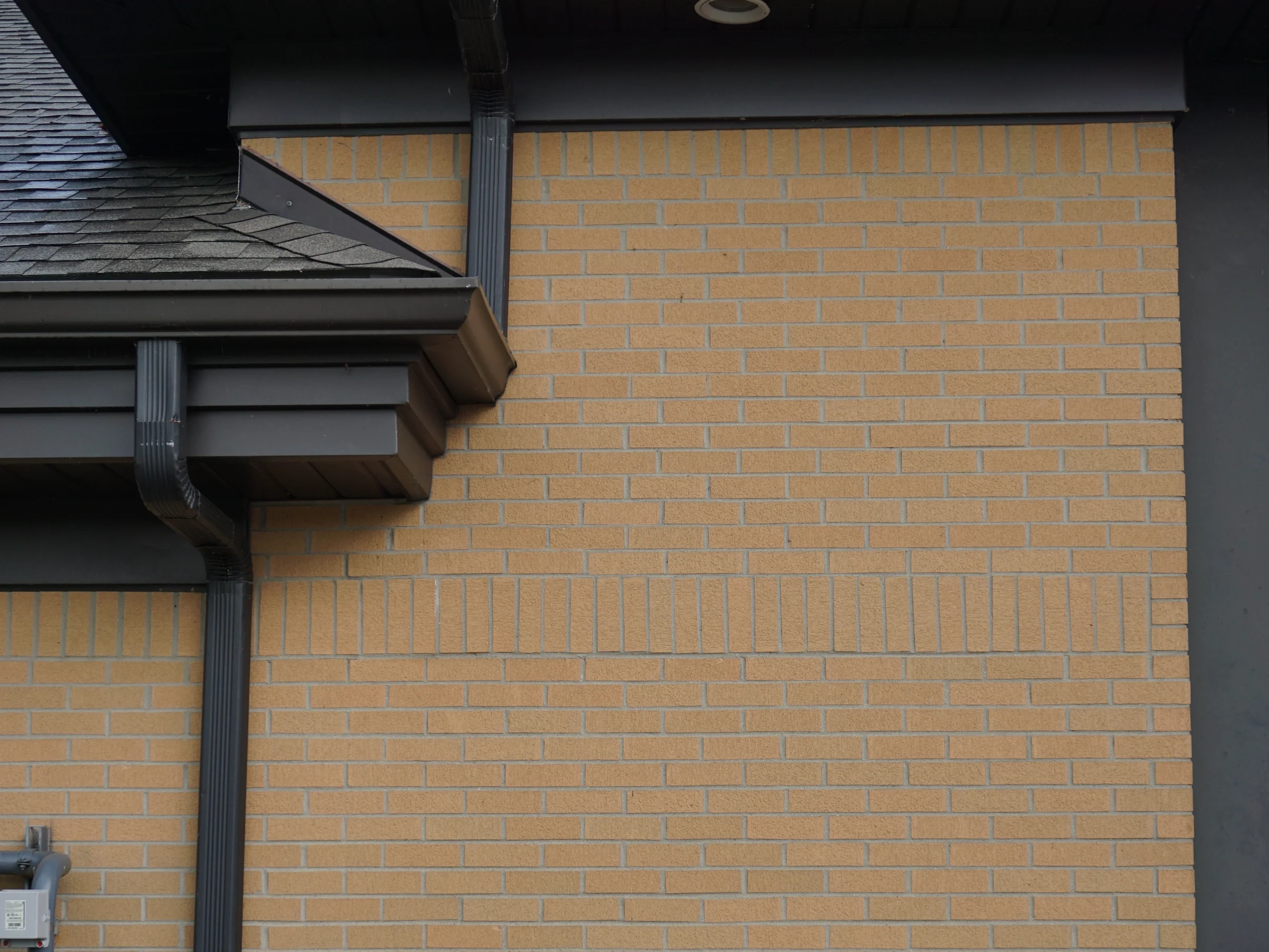 The tall end wall of the fire station in 2019, the course of upright brick near the top the same buff as the courses below it