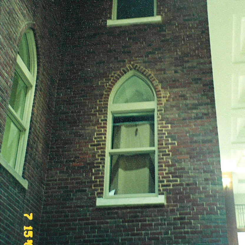 A pointed arch window in 2000 with a border of pale new brick around its head and jambs where the wall was rebuilt, and a camera date of 7 15 00 in the corner