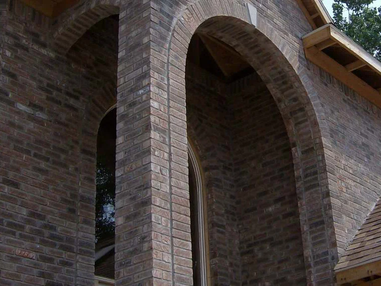Looking up under the entry arch in 2007, the soffit unfinished and the brick above the opening reading dark red beside pale grey units