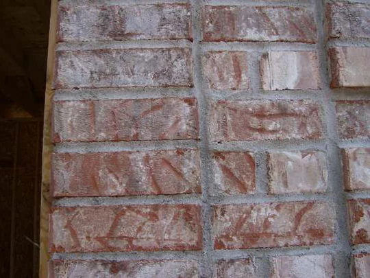 A close-up of the wall in 2007, salmon and cream brick alternating with deep red units across four courses of grey mortar