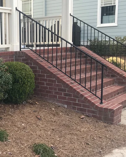 The front stair of a Tennessee house in 2022, the new brick in one range with the porch wall seven years after staining