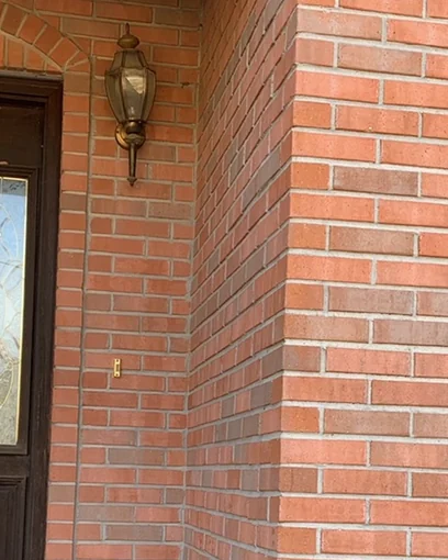 The front entrance of a Tennessee house in 2020, the brick beside the door one even range twenty-one years after staining