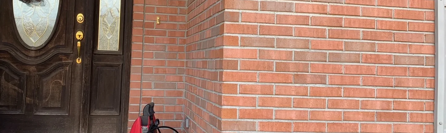 The front entrance of the Tennessee house in 2020, the brick beside the door and around the corner reading as one red range