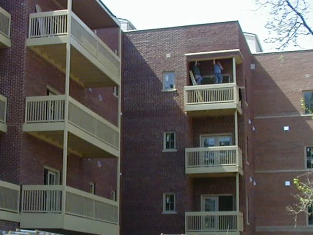 The balcony courtyard in 2004 after the blend, two men standing on an upper deck and the brick even across the piers behind them