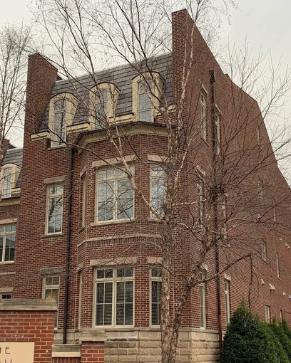 The corner bay of The Row apartments in Tennessee in 2021, the brick one even range seventeen years after staining