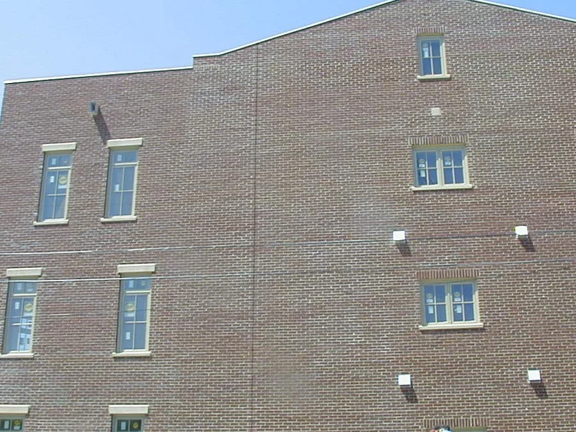 The stepped parapet wall in 2004, the brick running as one range from the window bands up to the roofline against a blue sky