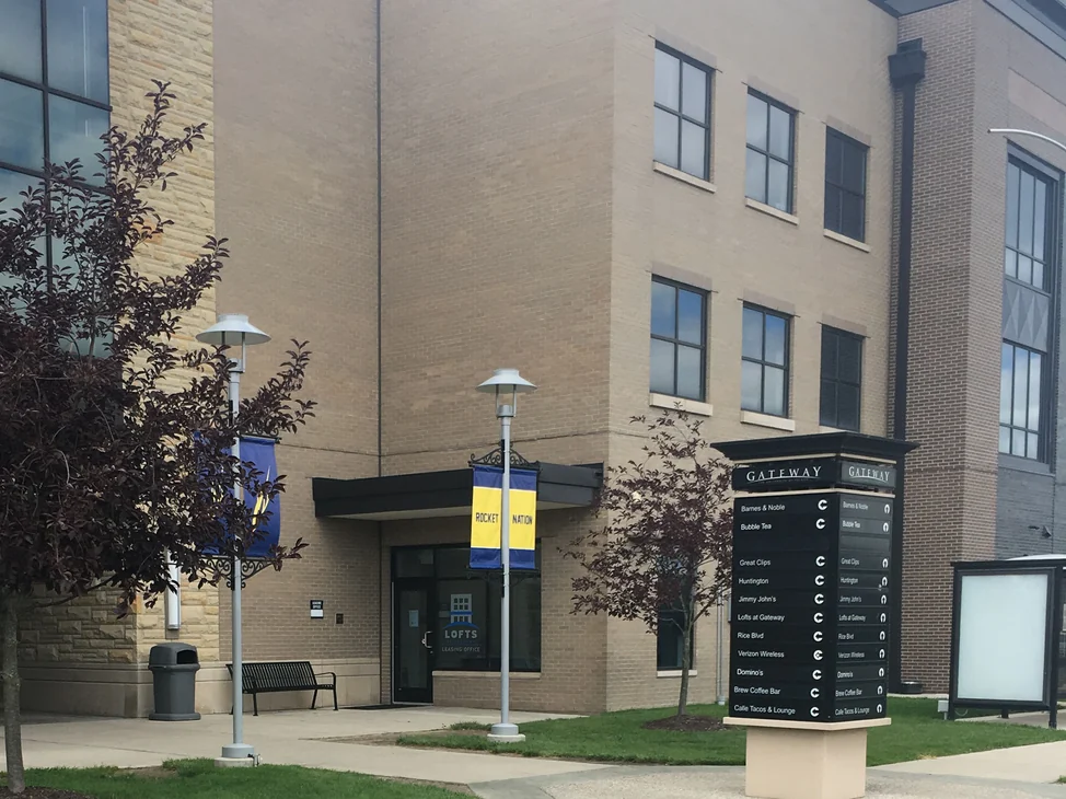 The corner of the Gateway building in Toledo in 2019, its buff brick reading as an even range behind the entrance canopy and the tenant directory on the plaza.