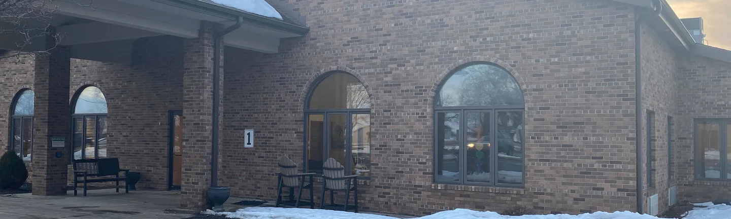 The gable wall of the Van Wert building in 2021, one range of tan and brown brick running from the new covered entrance past two arched windows