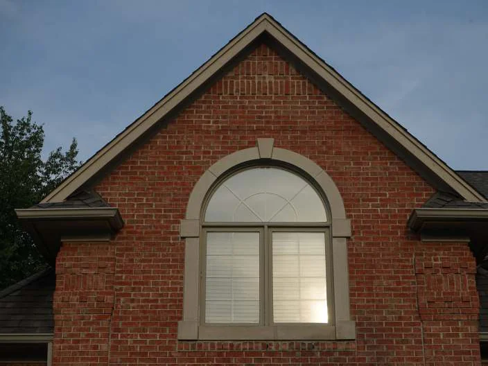 The gable with the arched window in 2019, the brick one even red range to the peak, a blind drawn behind the glass