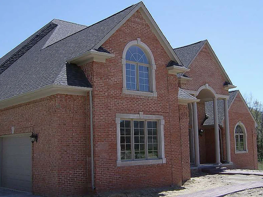 The garage wing and entrance of the new house in 2007, the brick a pale pink orange with darker units scattered through it, bare dirt where the lawn will go