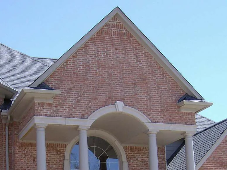 The entrance gable above the portico columns in 2007, the brick pale pink and uneven against a clear sky