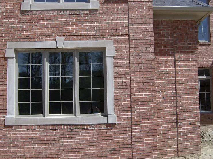 A side wall in 2007 around a stone-trimmed window, the brick pink and mottled, with a brick corner and the roof of the bay beyond