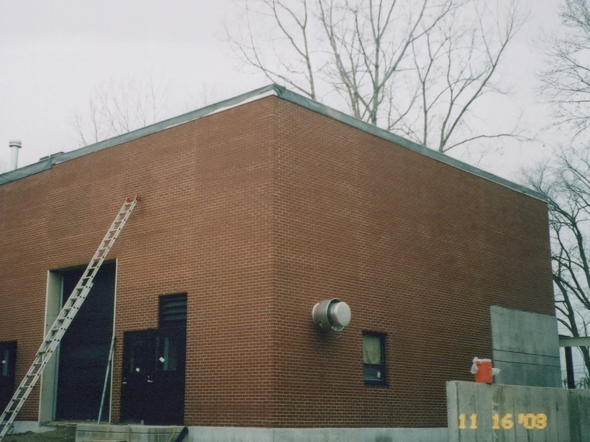 The same corner in November 2003 with an extension ladder against the wall beside the roll-up door and a camera date of 11 16 03 on the concrete wall at right