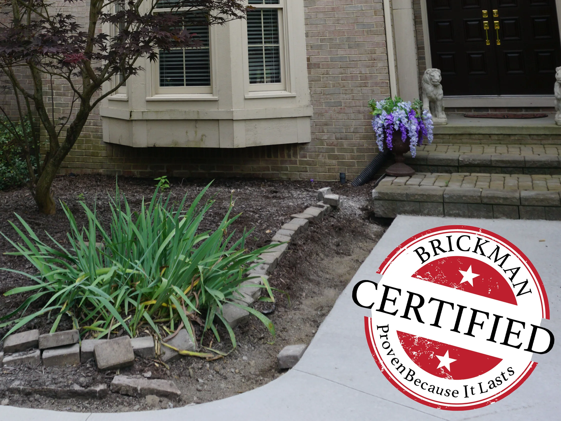 The front walk and entry steps in 2019, the brick under the bay window and beside the doorway holding the same buff and gray blend