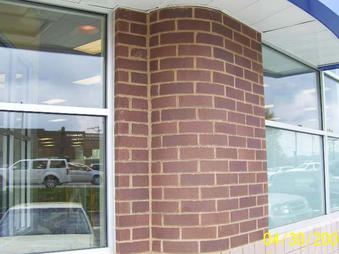 The same rounded brick corner in 2008 after the work, the units carried to one even red brown under the soffit, the burned-in camera date reading 04/30/200