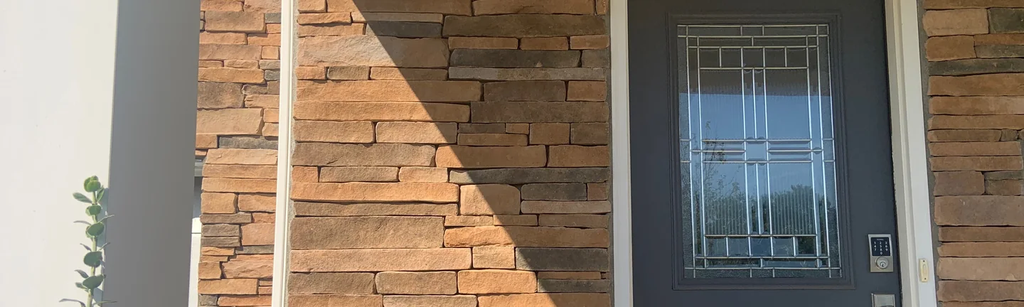 The covered front entry of the Westerville house in 2019, its stacked stone an even range of tan, rust and grey