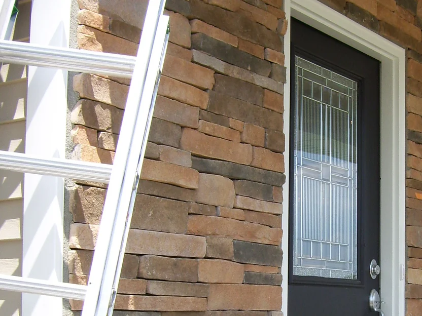The front entry during the work in 2012, a ladder standing against the stacked stone beside the door