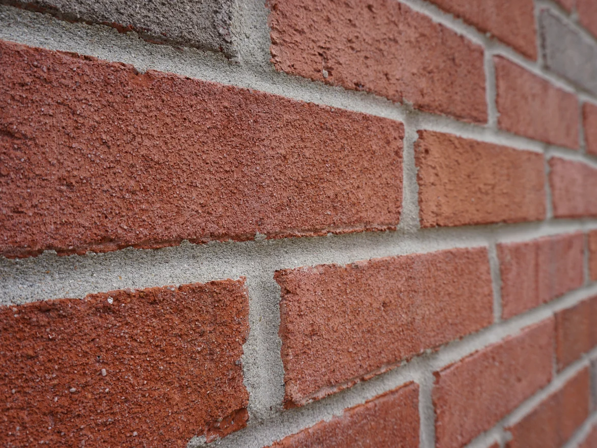 Close view of the blended brick in 2019 seen along the wall, red and grey units sitting in the same range with pale sanded mortar joints