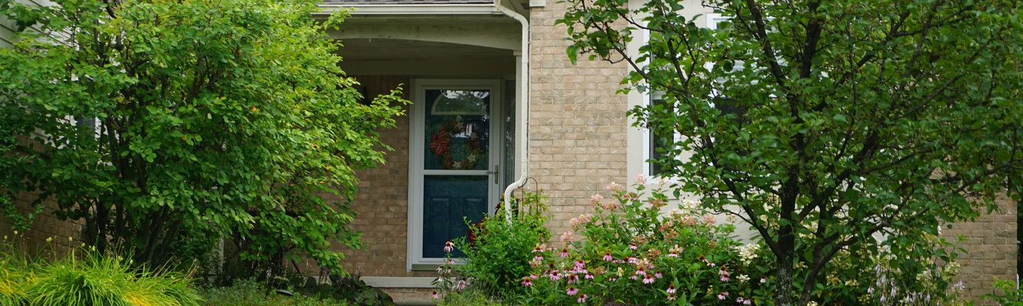 The front entry of the Wixom house in 2019, its buff brick reading as one even range around the door