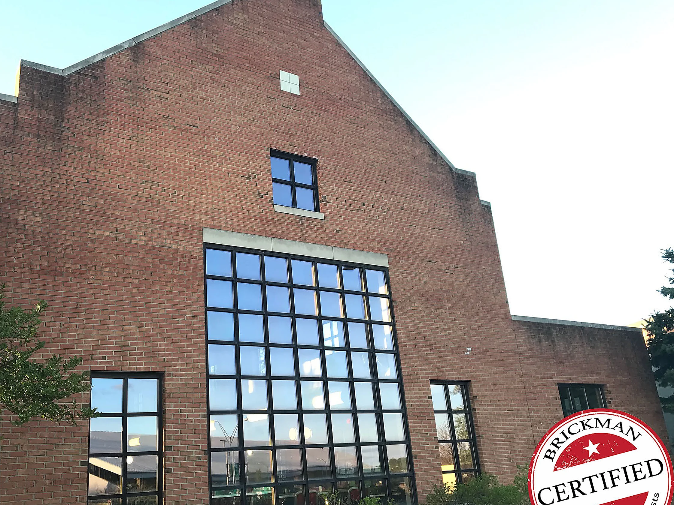 The gable end of the building in 2019 from the lawn, the tall window under the gable and the wing beyond all reading as one even red brick