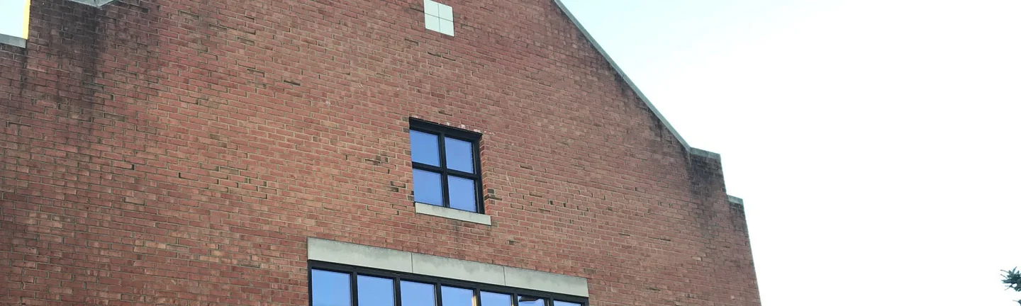 The gable end of the Youngstown State building in 2019, its brick reading as one even red across the whole wall