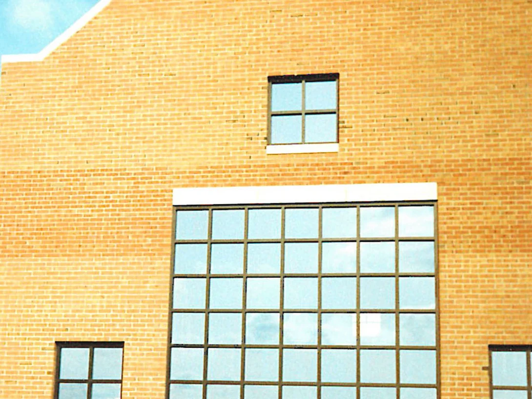 The gable end wall in 1995, its brick a pale tan with darker units scattered through the courses around a small square window